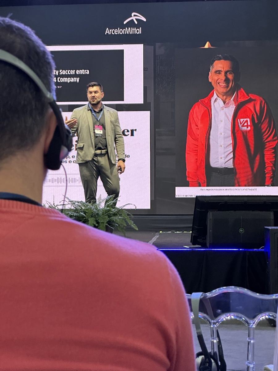 Júnior Kloh no palco, com a ArcelorMittal no telão