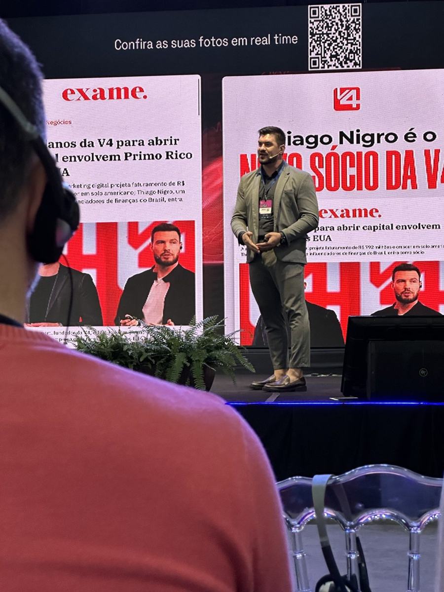Júnior Kloh no palco durante palestra